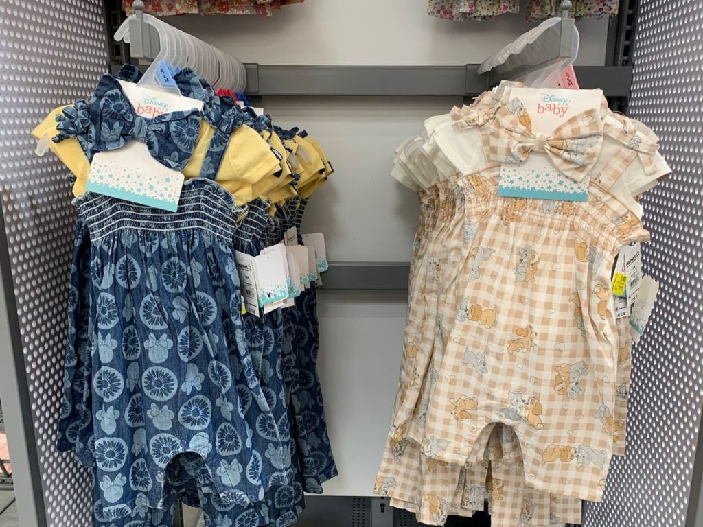 Disney Baby Romper Sets hanging on racks at Walmart