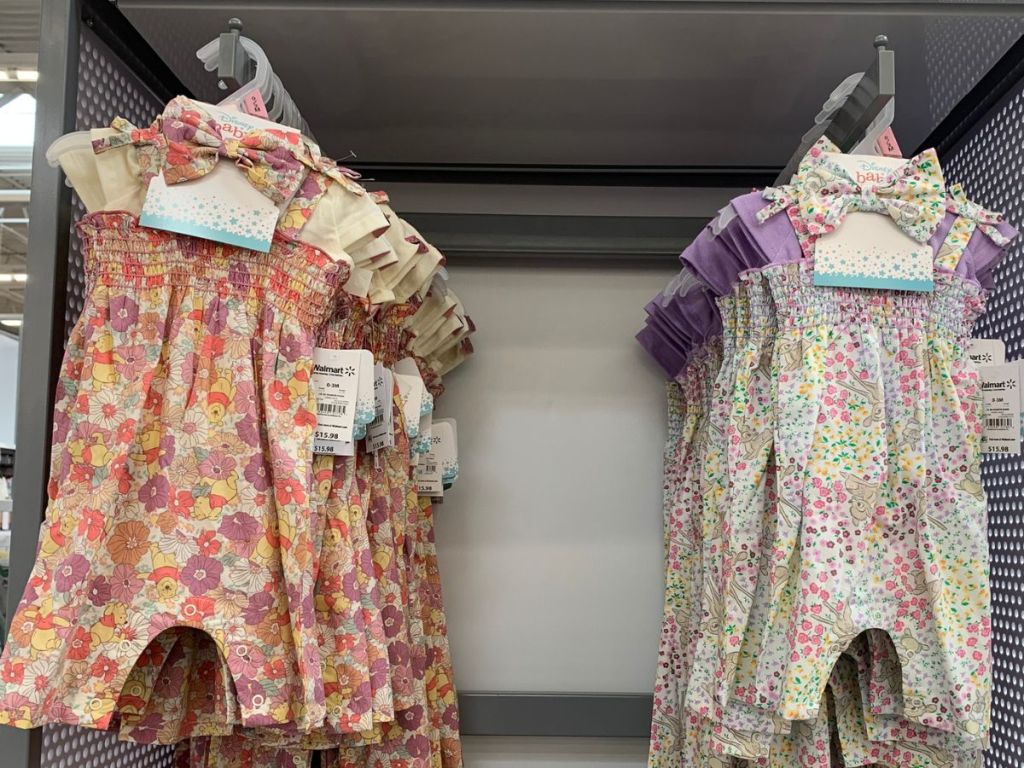 Disney Baby Romper Sets hanging on racks at Walmart