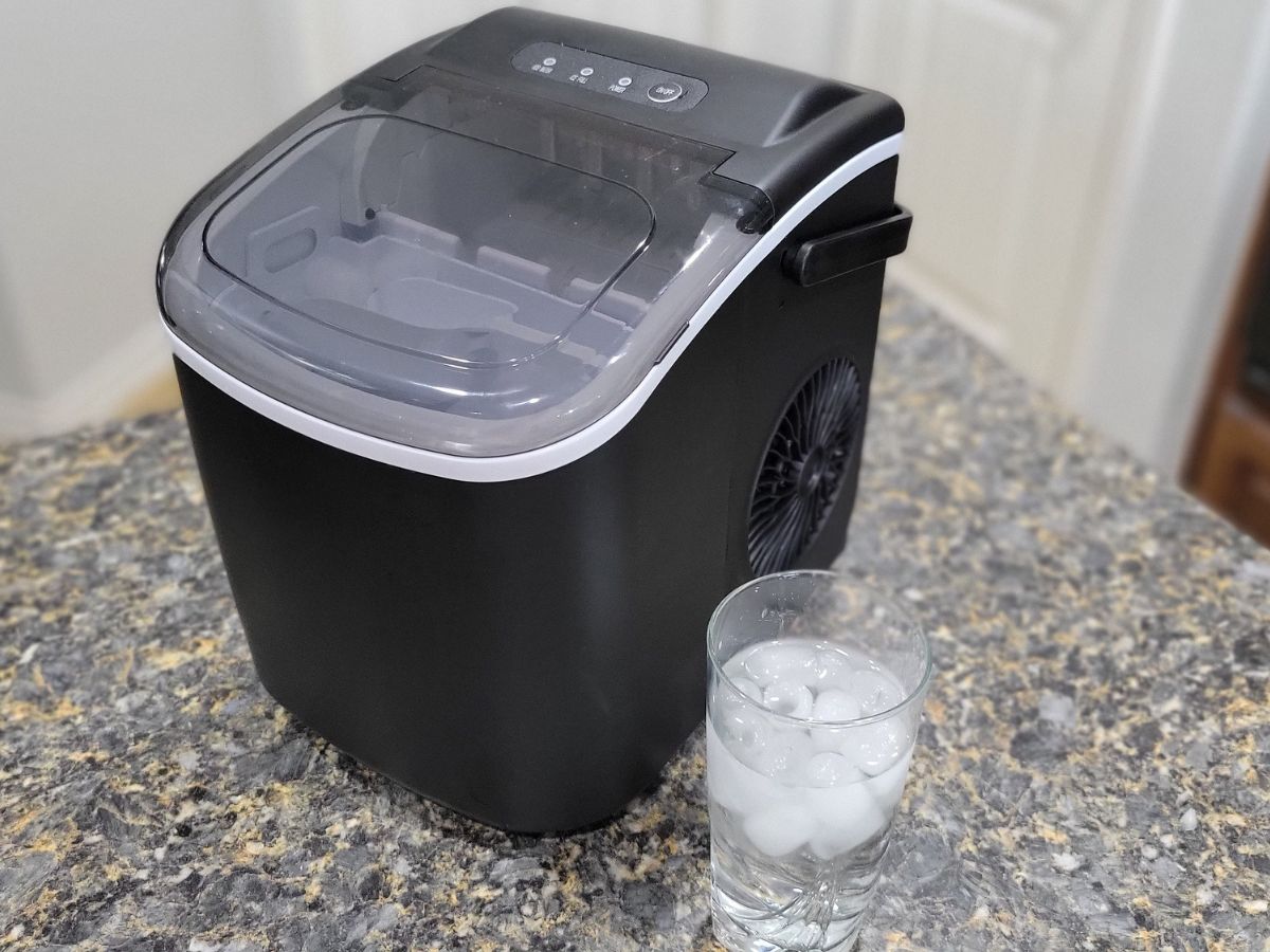 Free Village Ice Maker on counter next to glass filled with ice and water