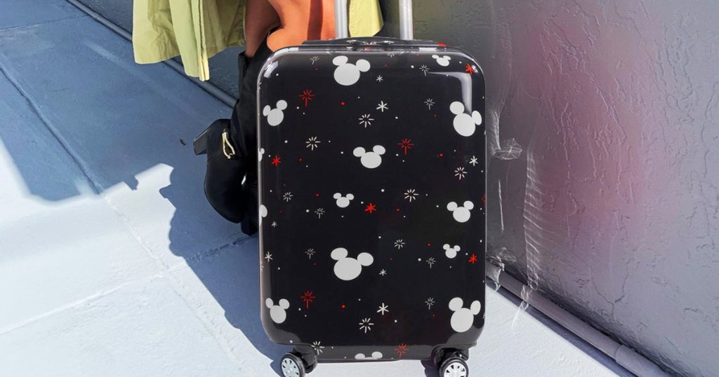 woman standing with disney print luggage