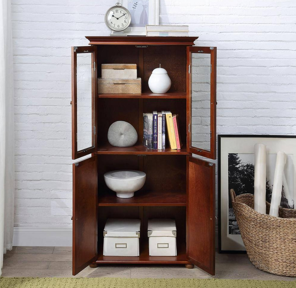 Wood cabinet with the doors open and books, bins, and home decor inside