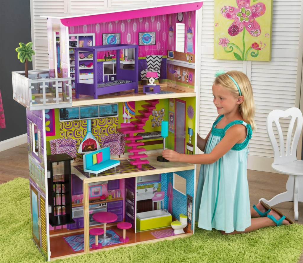 girl playing with pink and purple dollhouse