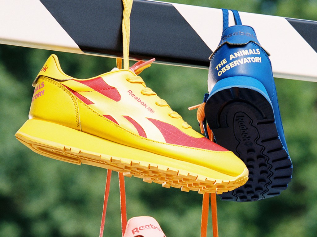 yellow and blue reebok leather sneakers hanging from pole