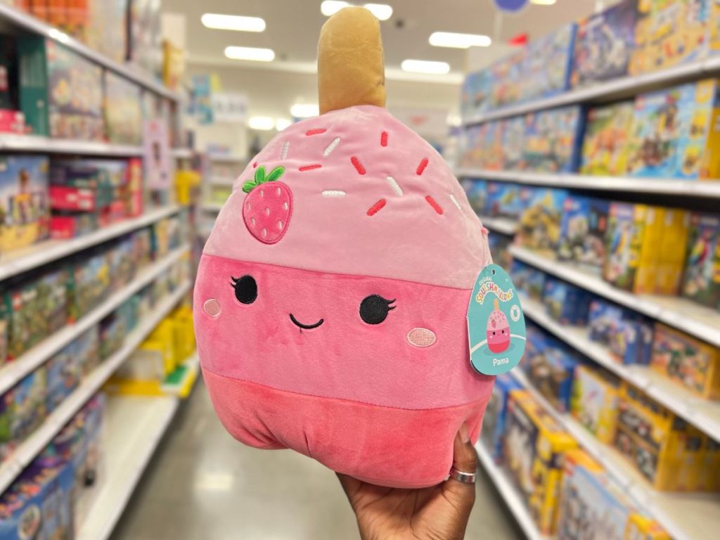 hand holding Squishmallows 11" Pama the Pink Strawberry Cake Pop Plush Toy