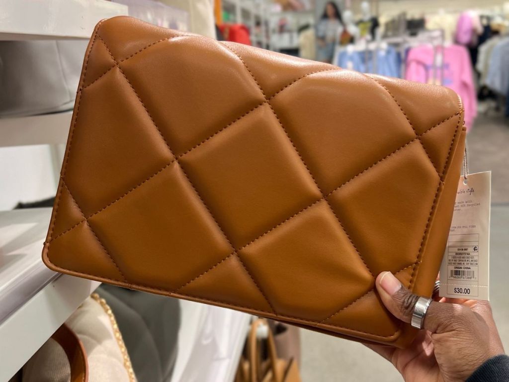 Hand holding up a Crossbody bag at Target