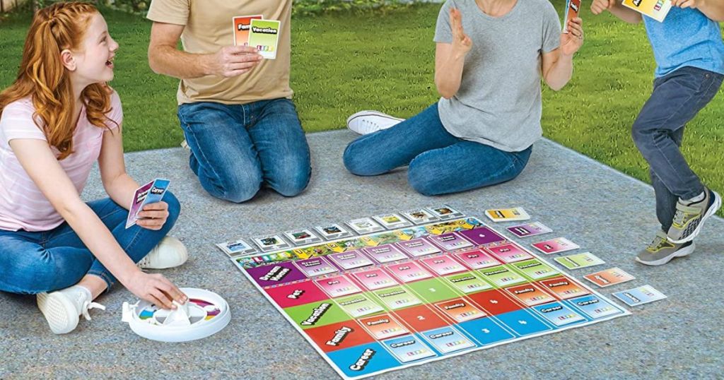 family palying giant Life board game outside