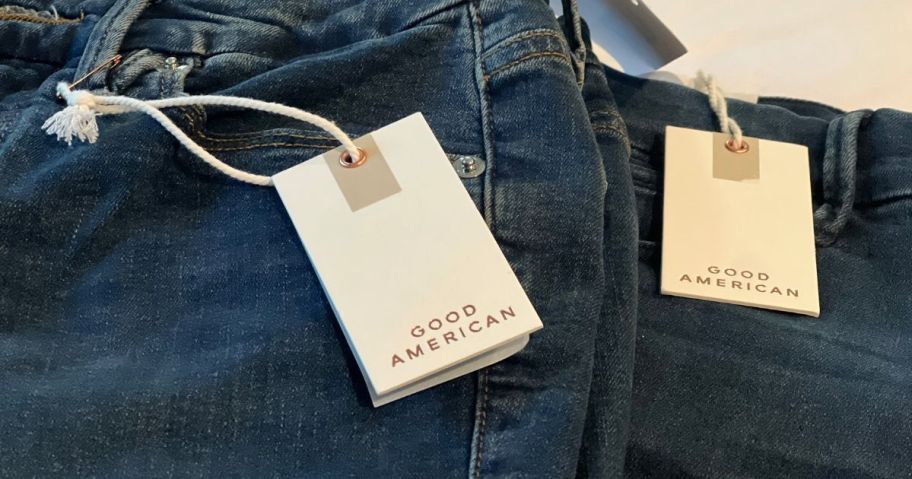 a pair of good american dark wash jeans with tag attached