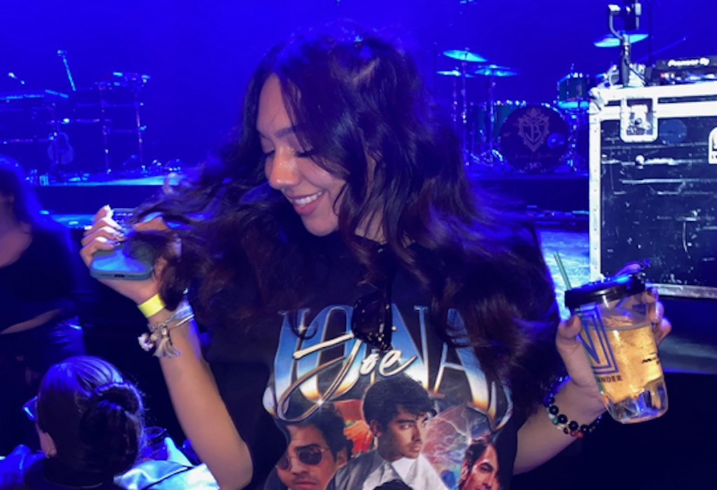 woman dancing at concert holding drink