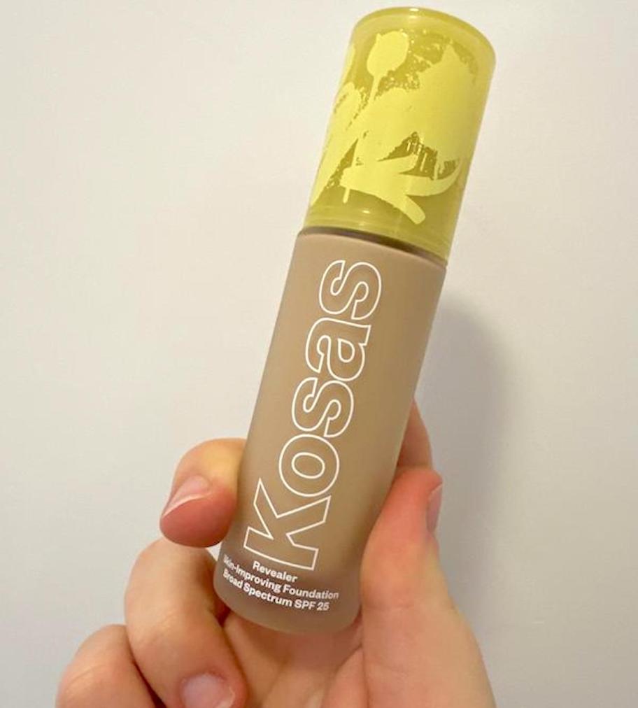hand holdingi kosas bottle of foundation