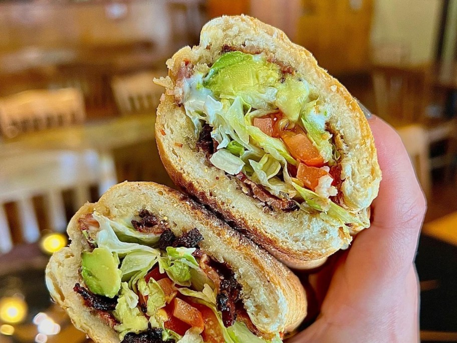 holding 2 halves of a sandwich