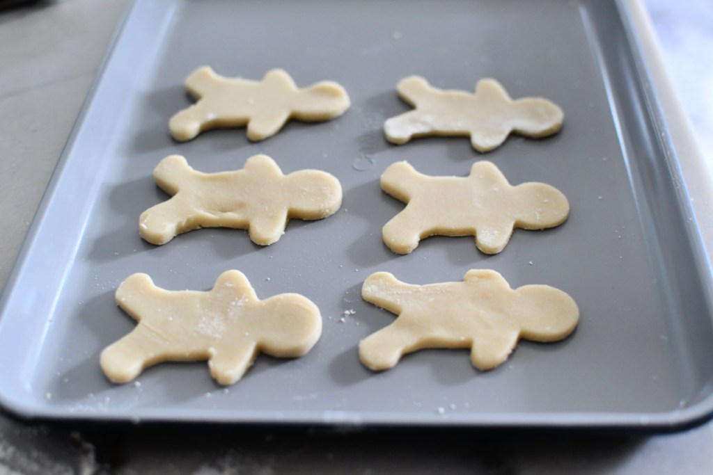 rolled out sugar cookie dough gingerbread man bunnies on a sheet pan