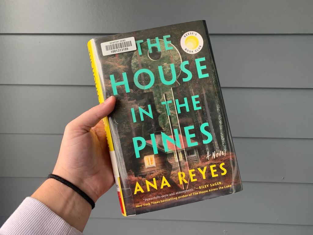 hand holding the house in the pines book