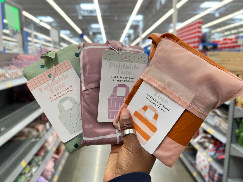 three different pattern foldable totes in woman's hand