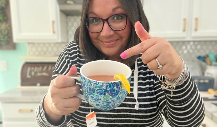 woman pointing to a hot cup of tea