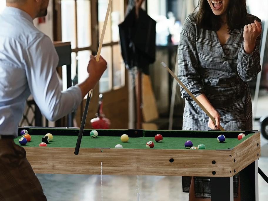 People play pool on the 13-in-1 Multi Game Table