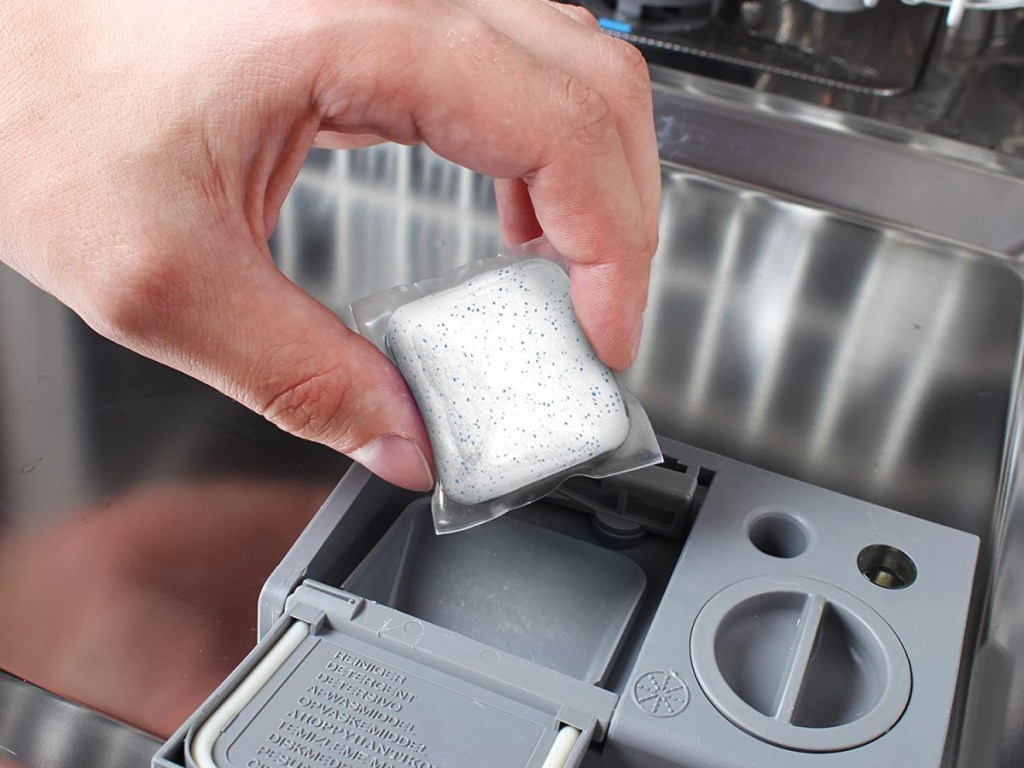 person putting an Amazon Basics Dishwasher Detergent Pac into a dishwasher