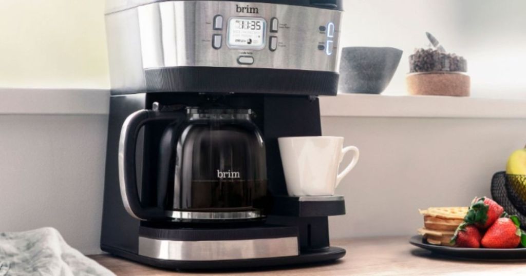 Coffeemaker with a glass carafe and a mug on it