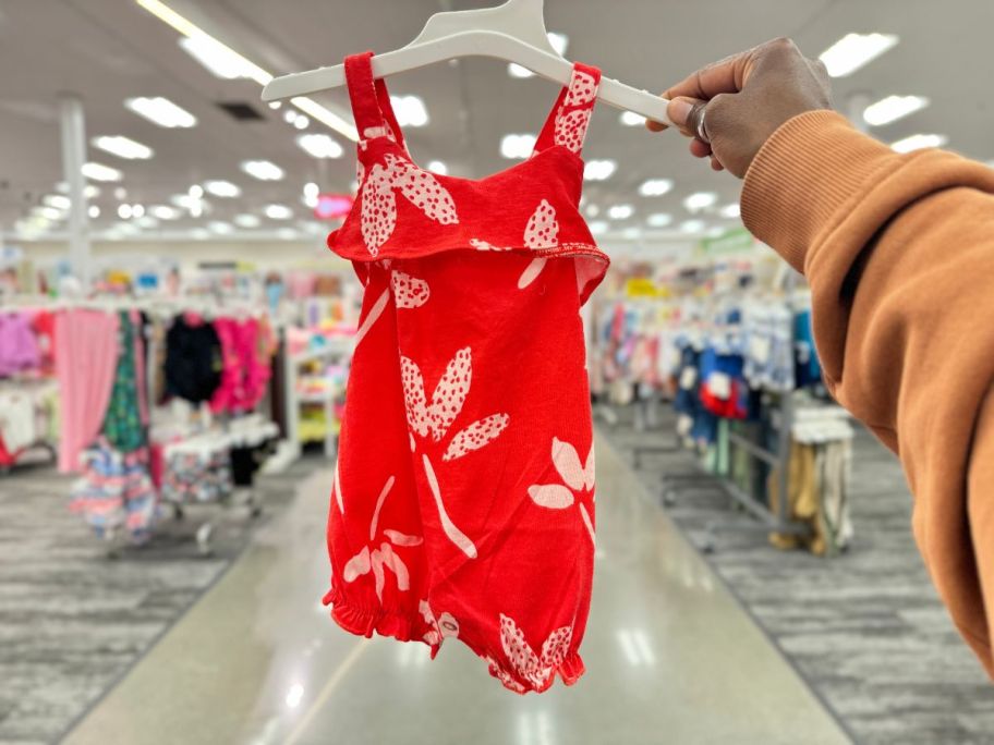 A hand holding a Carter's Just One You Baby Floral Top & Bottom Set with Headband