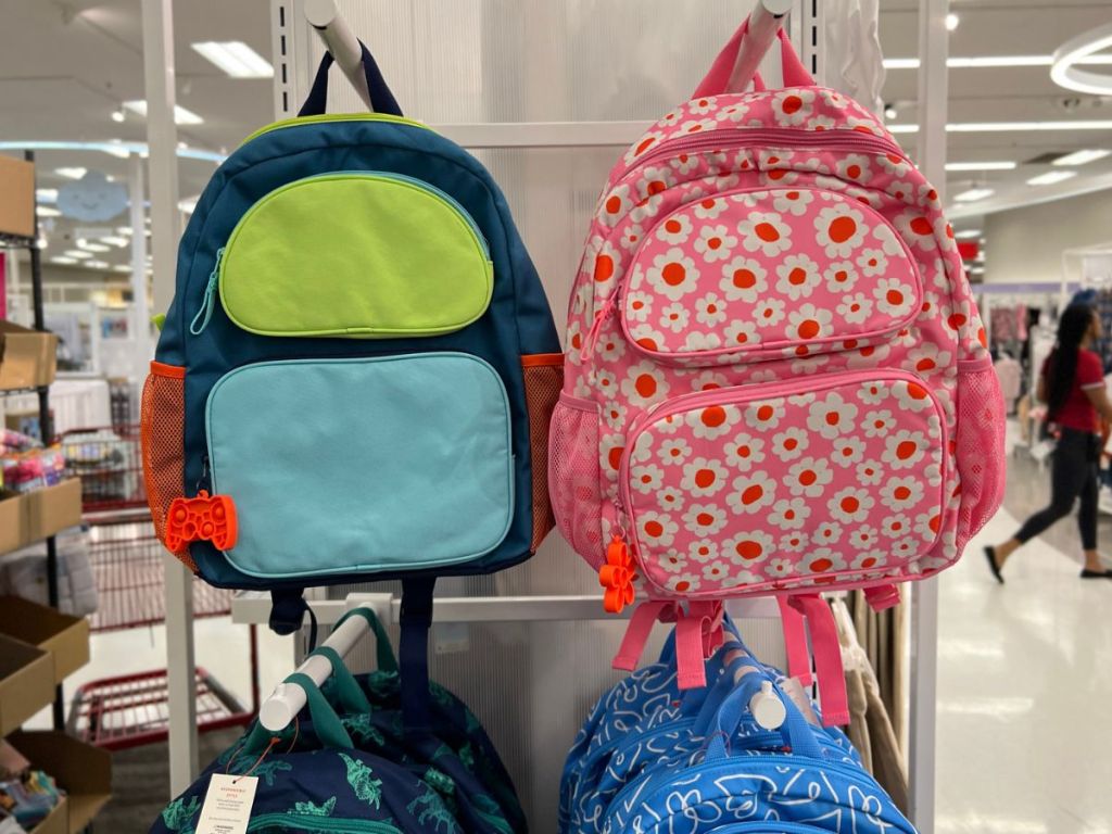 2 backpacks one green and blue and the other pink with flowers