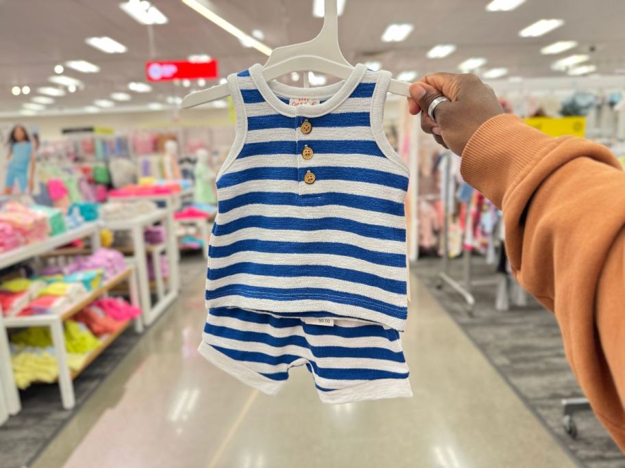 A hand holding a Cat & Jack Blue and White Striped Newborn Romper