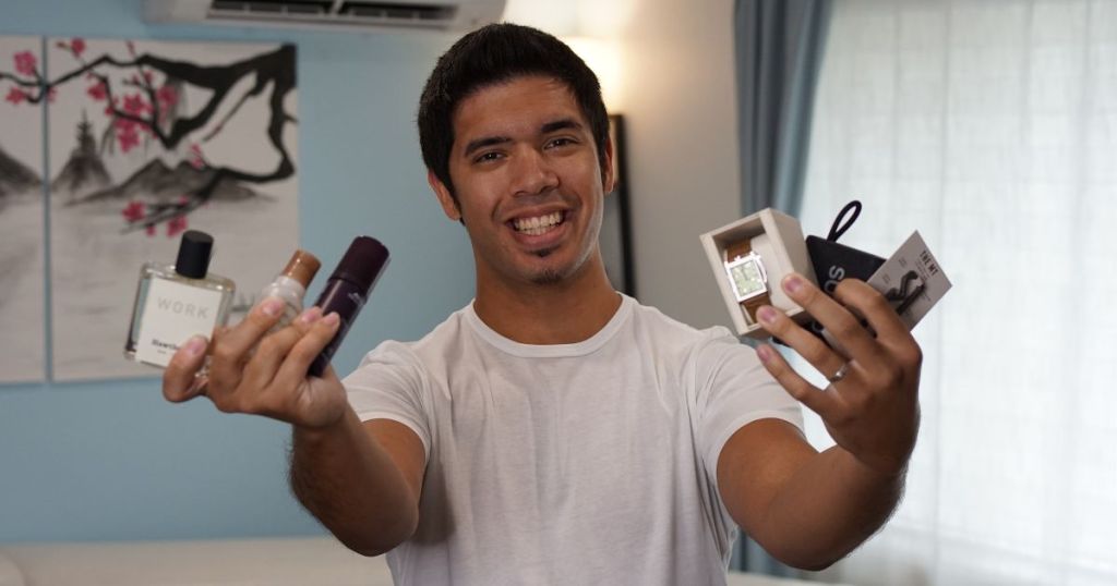 man holding mens care items in both hands