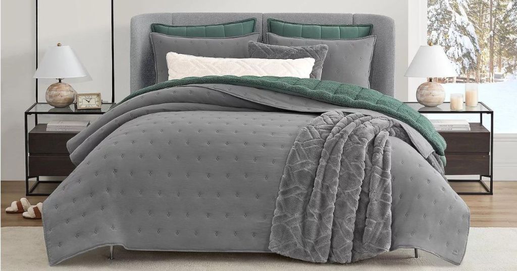 A gray comforter on a bed