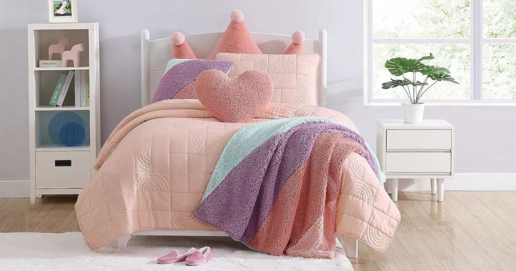 a child's room with a pink comforter