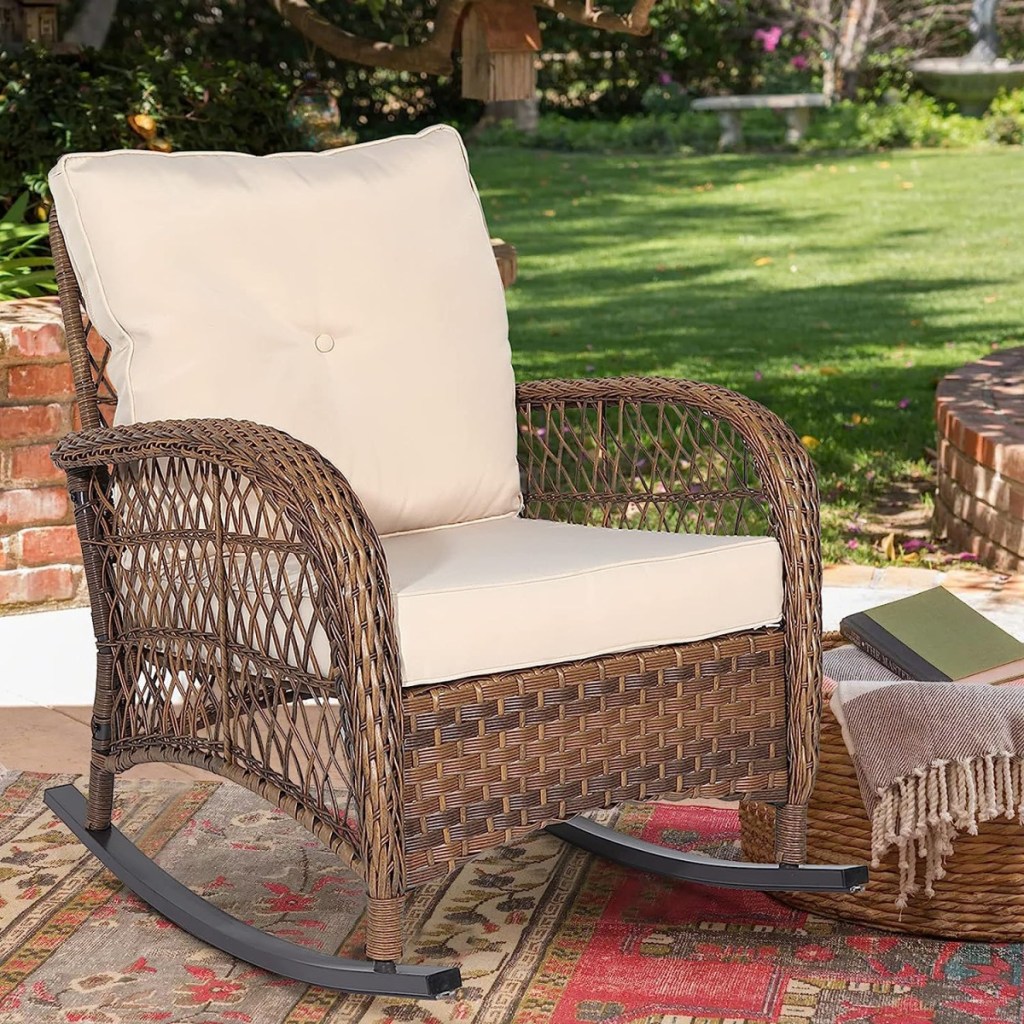 a wicker rocking chair with cushion outside on a patio