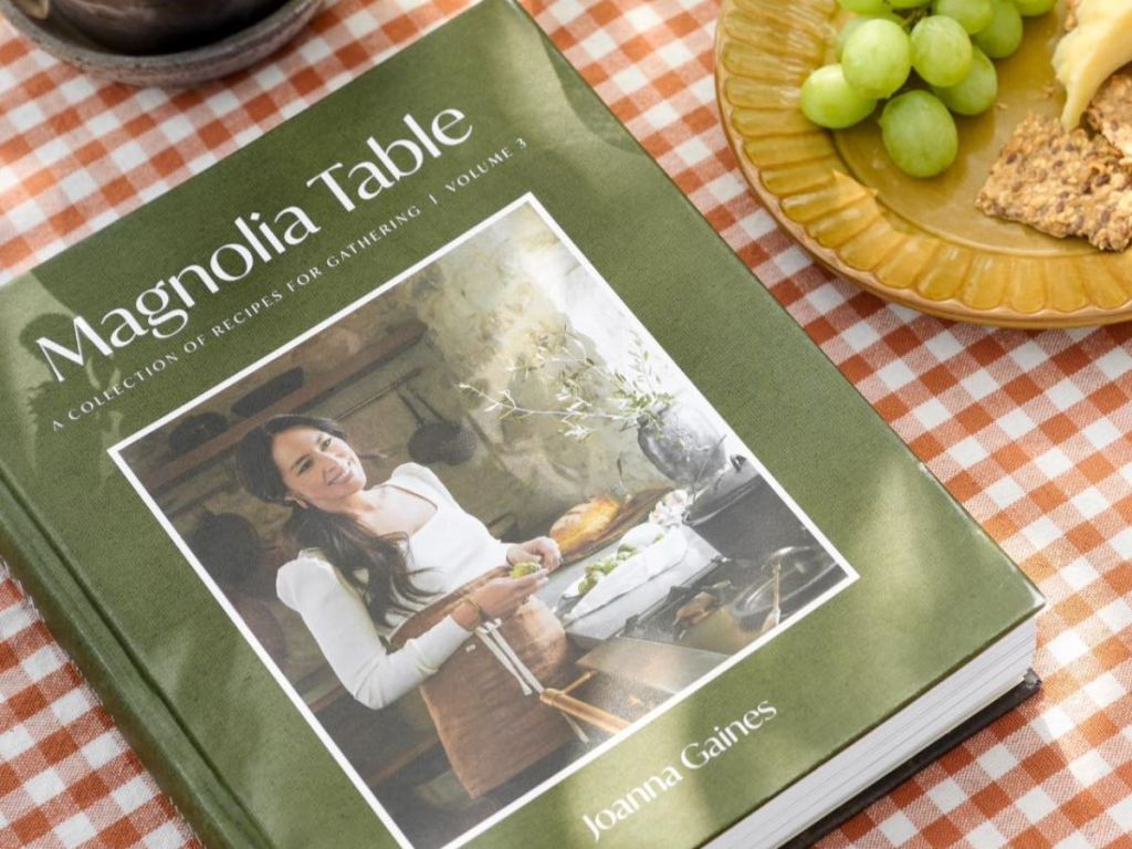 Magnolia table book on a table next to a plate of food