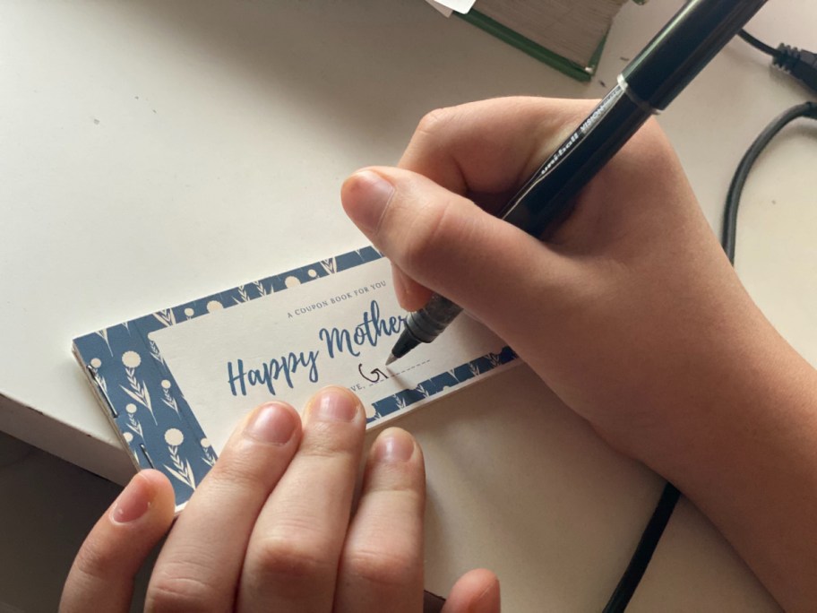 girl addressing her free coupon book for mom