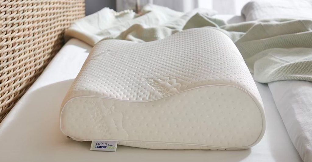 TEMPUR-Neck Pillow on a bed