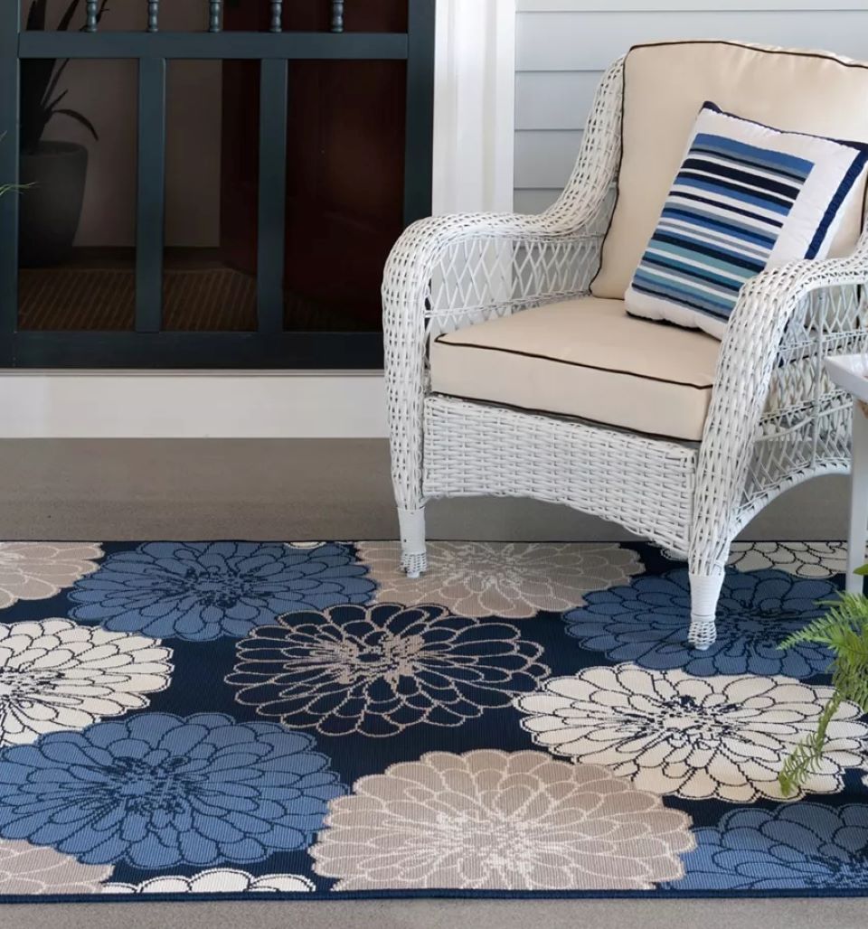 White patio chair sitting on a blue floral rug