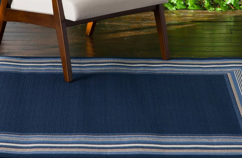 Blue area rug with a striped border
