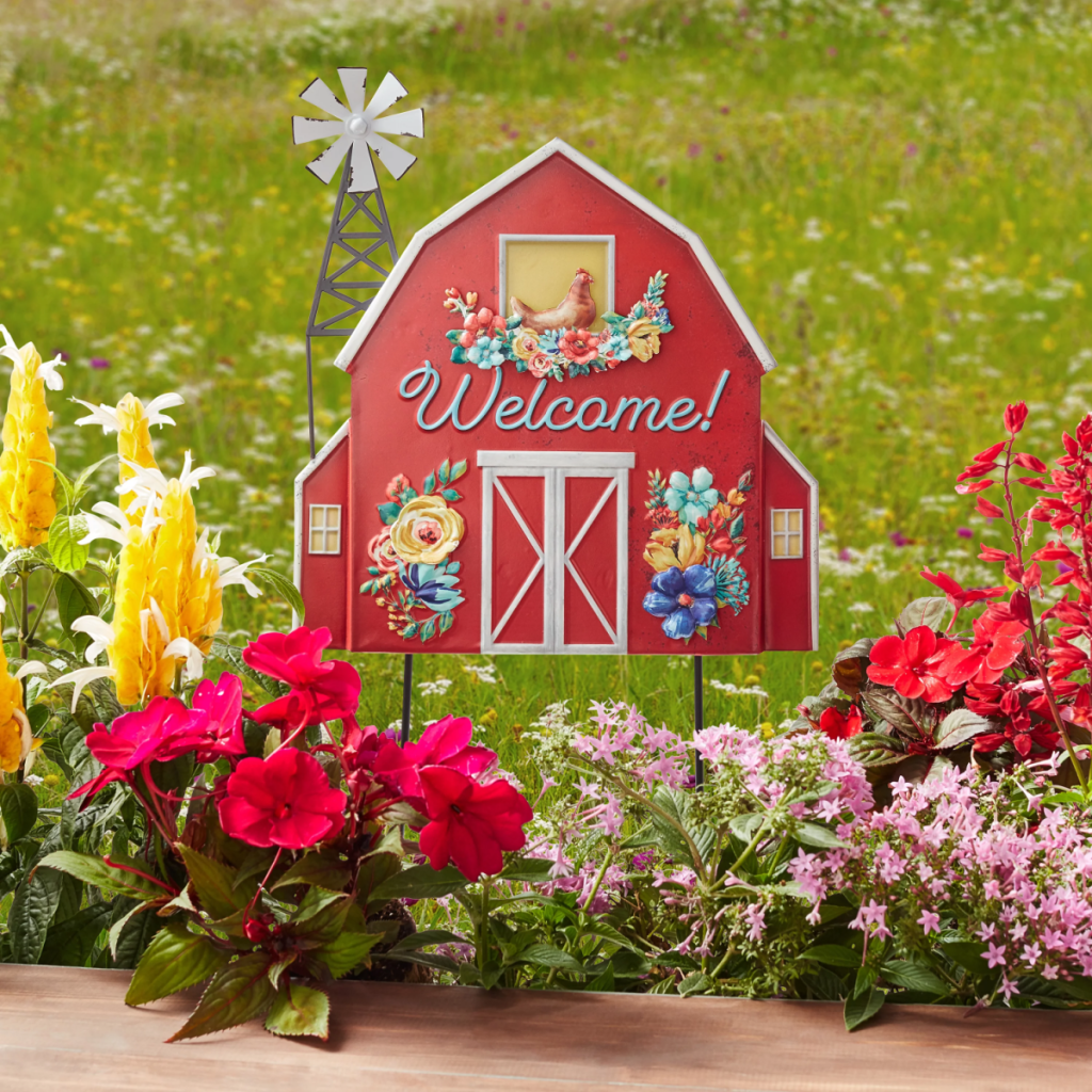 The Pioneer Woman Red Barn Garden Sign displayed near a flower bed 