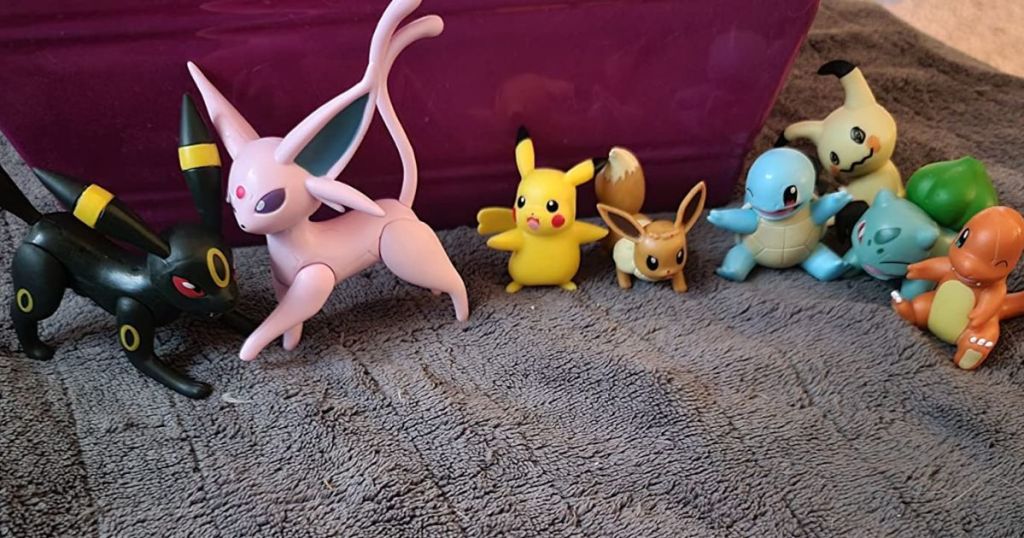 Pokemon Battle Figures lined up next to each other on a bed