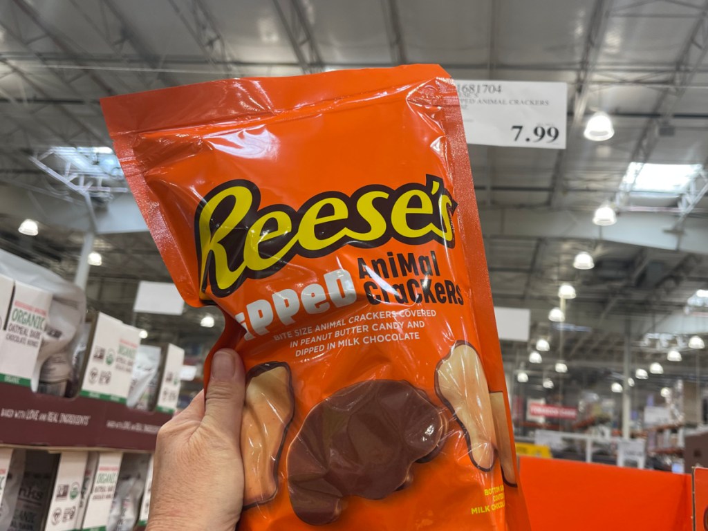 person holding up bag of Reeses Dipped Animal Crackers in costco