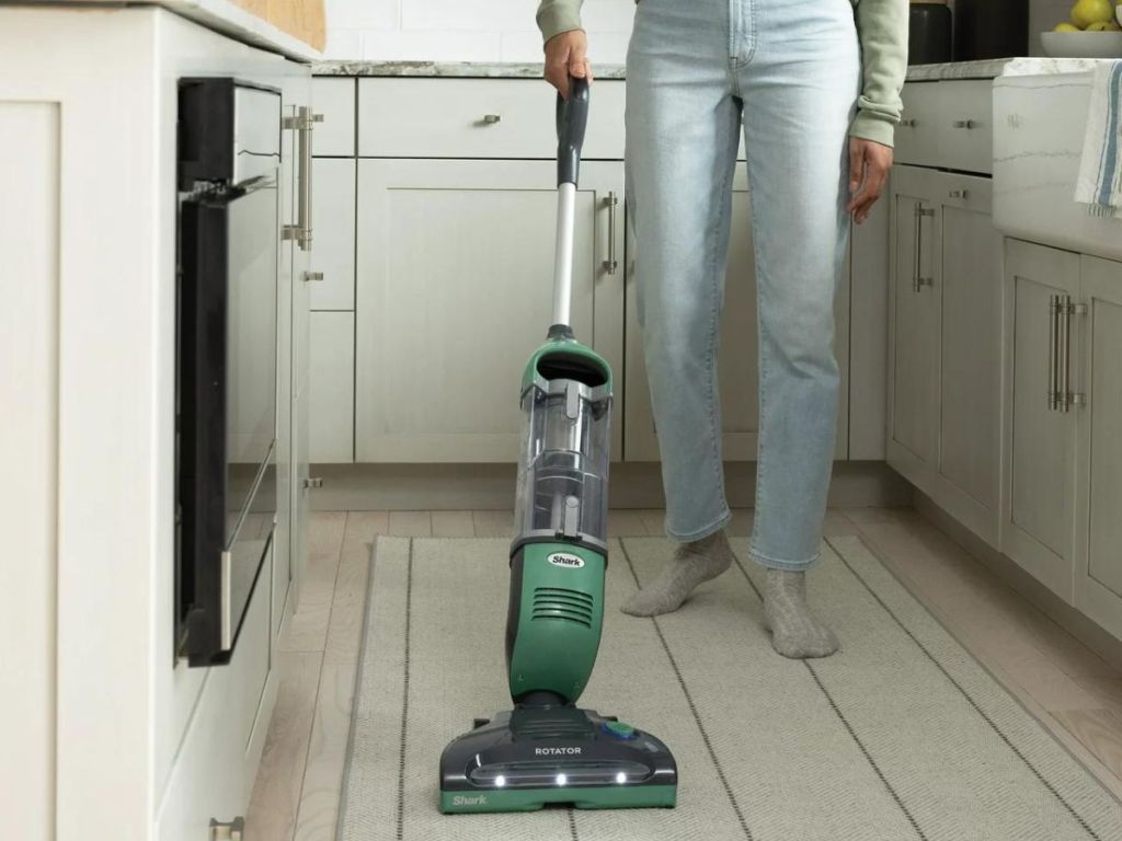 woman vacuuming a kitchen floor