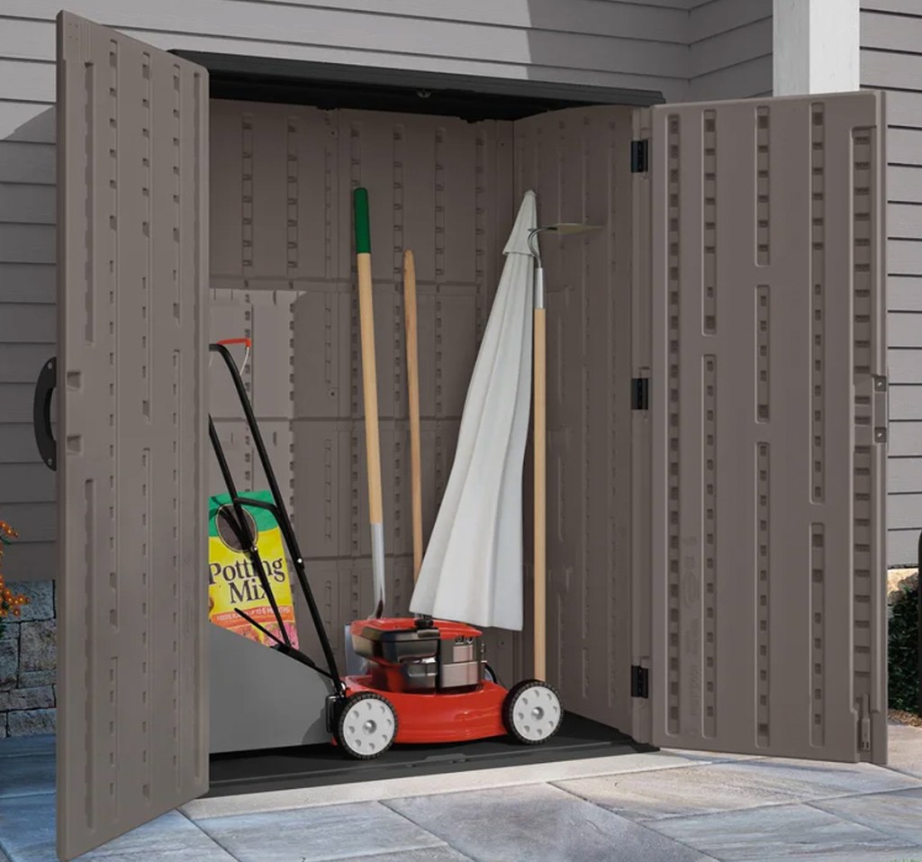 opened storage shed with lawn mower and garden tools inside