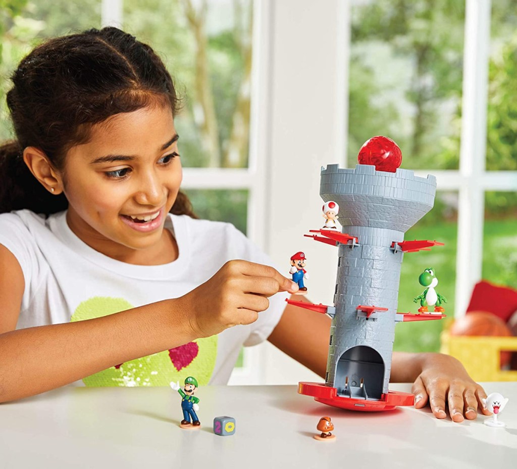 Girl playing with super mario figures and tower game