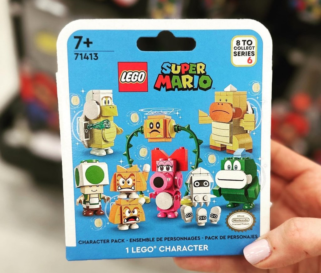 Woman holding up a box of Super Mario Figures by Lego