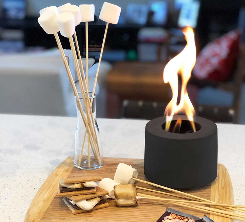 mini fire pit on cutting board with smores supplies
