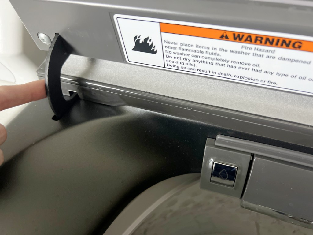 Woman pointing to the hinge on her washing machine