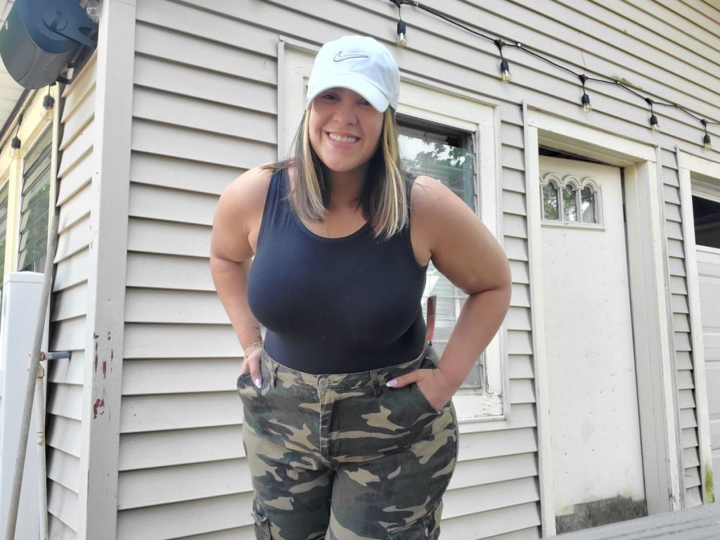 Woman in a black bodysuit and camo pants