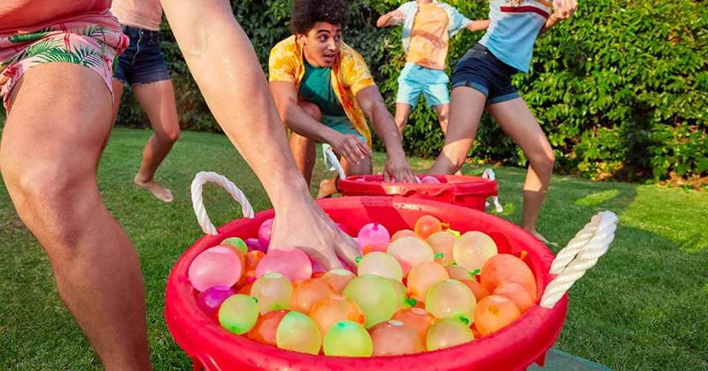 Zuru bunch o balloons tropical party water balloons in a big read bucket with people having a balloon fight
