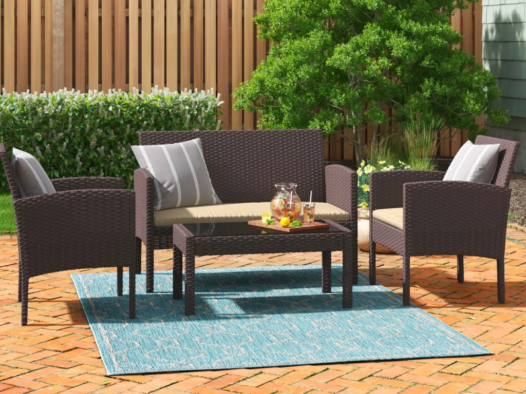 brown rattan patio set on porch with teal rug