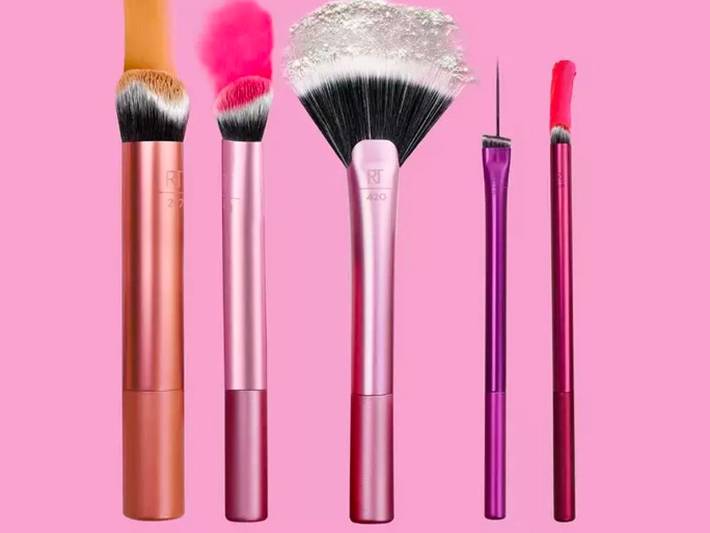 5 makeup brushes on pink background