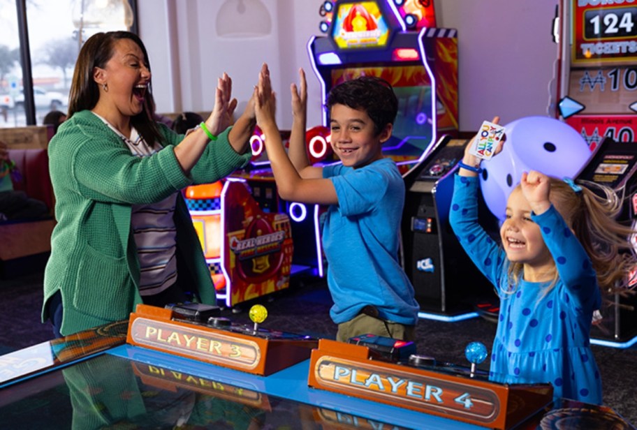 woman playing games with kids at Chuck E Cheese