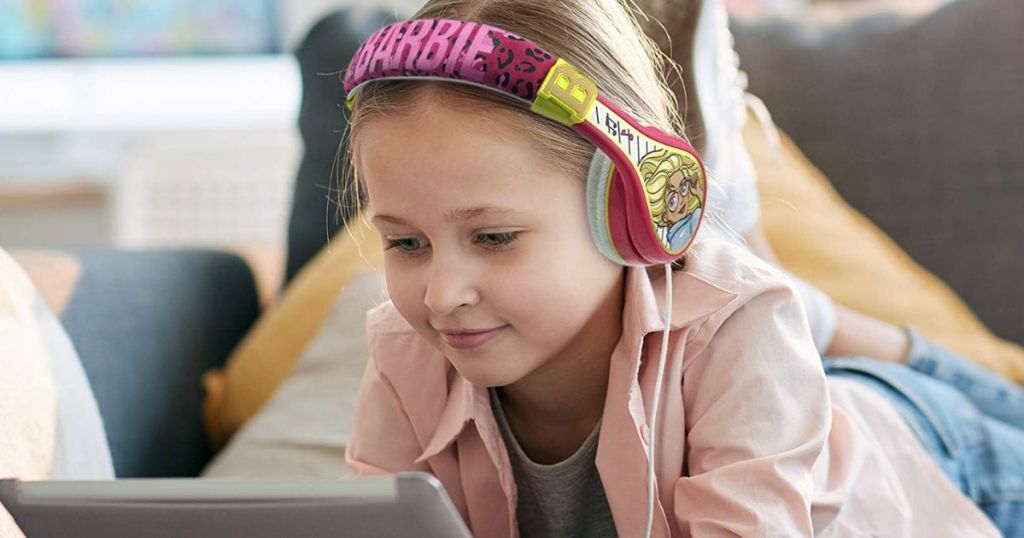 a girl on a tablet with pink Barbie headphones