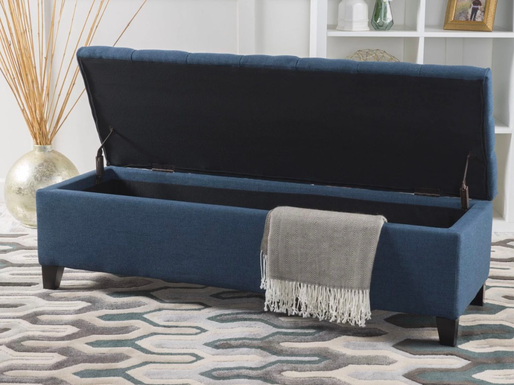dark blue entryway bench open with blanket hanging out