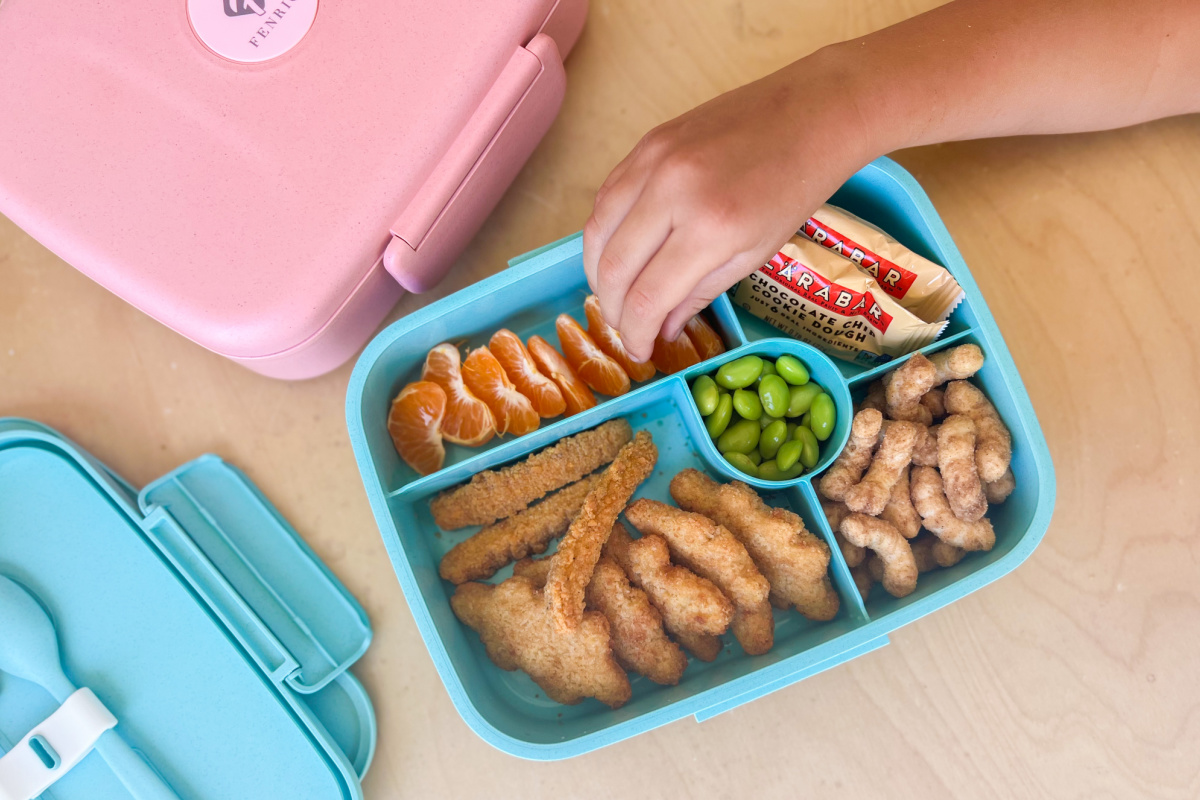 hand grabbing food out of bento box